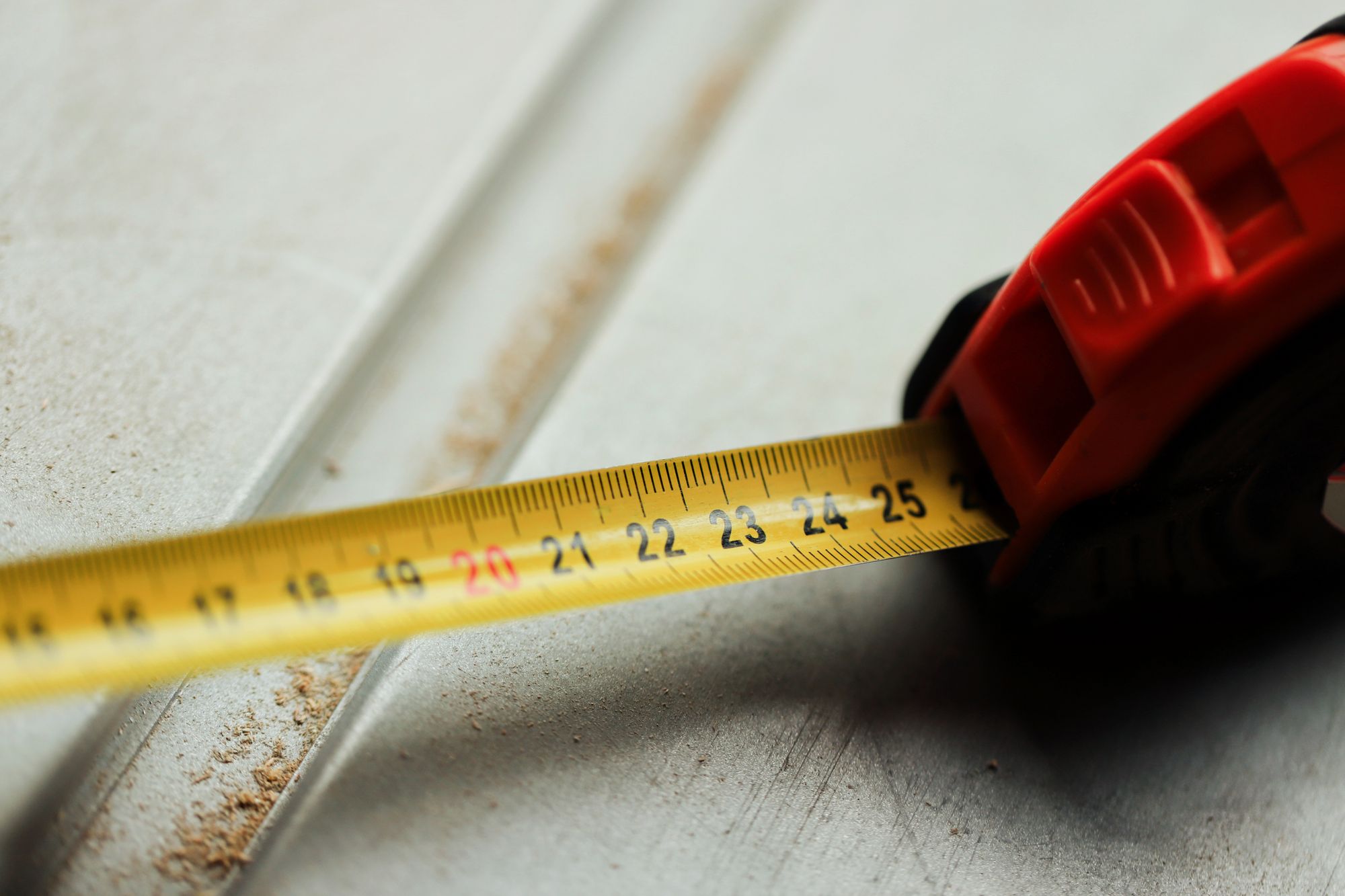 Close-up of a tape measure on a construction site, representing McLains' quantity surveying and construction management services
